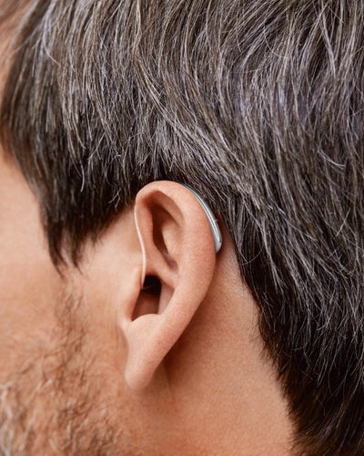 A mean wearing a Signia hearing aid.