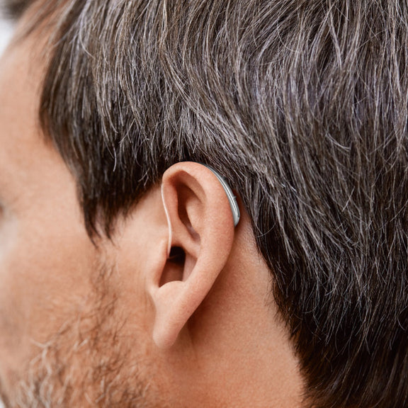 A mean wearing a Signia hearing aid.