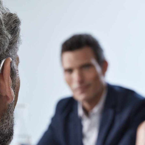 man wearing phonak hearing aid while communicating