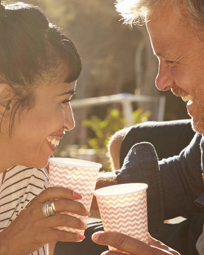man and woman socialising outdoors wearing hearing aids