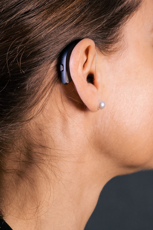 A person wearing a Resound ONE hearing aid.