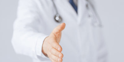 An audiologist shaking hands.