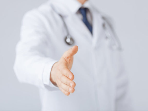 An audiologist shaking hands.