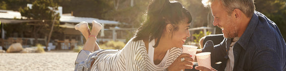 Two people wearing hearing aids enjoying a picnic.