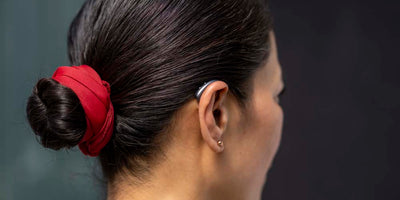 Someone wearing a Signia IX hearing aid on their right ear.