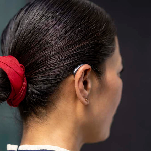 Someone wearing a Signia IX hearing aid on their right ear.