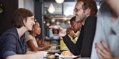 people chatting at a busy table wearing hearing aids