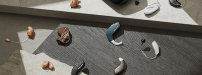 Resound hearing aid charger surrounded by Resound hearing aids.