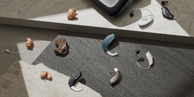 Resound hearing aid charger surrounded by Resound hearing aids.