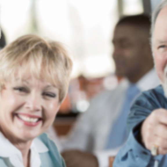 elderly people communicating happily while wearing hearing aids