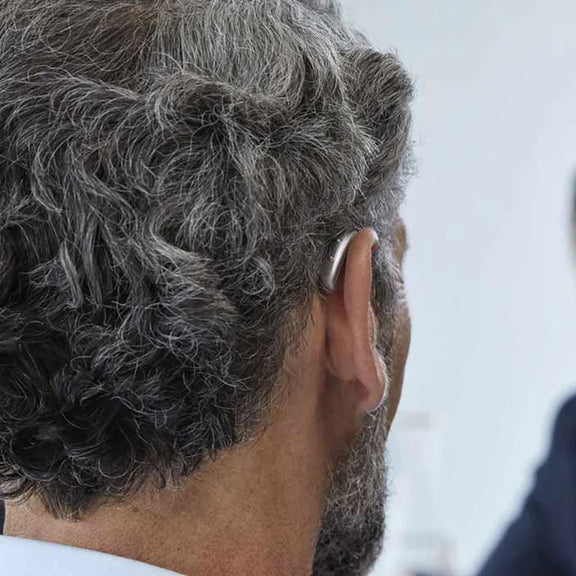 man wearing phonak hearing aid behind ear